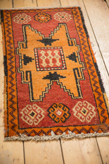 Detail of distressed Oushak rug, tangerine and brick red geometric stepped medallion, zig-zag border.