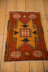 Distressed Oushak rug corner displaying brick red zig-zag border and faded geometric shapes.