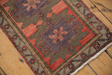 Vintage Turkish Oushak rug's geometric blush, aubergine, and olive floral motifs with fringed edge.