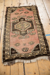 Distressed Oushak rug corner, light tatter on fringe, running water border pattern.