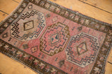 Distressed Oushak rug's central gul motif with floral, serpent designs in blush, bronze, blue.