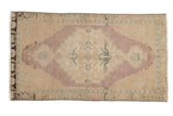 Vintage distressed Oushak rug mat, dusty mauve serrated medallion on an open beige field, 1'8