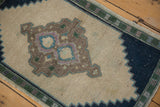 Navy stepped spandrel and pale green border on the distressed ivory Oushak rug.