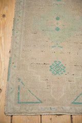 Distressed Oushak rug corner, even wear to knot heads, pale green motifs.