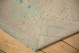 Distressed Oushak rug with pale green pile, short fringe, and visible hand-knotted reverse.