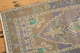 Distressed Oushak runner with textural pile, lilac, mint, and sand motifs, plus fringe.
