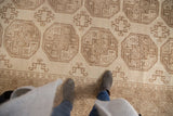Distressed vintage Ersari carpet, ivory and dusty beige, with classic elephant footprint gul motifs.