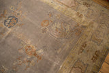 Distressed Art Deco Indo carpet corner, faded mauve grey field, pale gold geometric border.