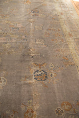 Distressed texture of the faded mauve grey Art Deco carpet field with symbolic motifs.