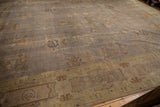 Distressed Art Deco carpet with faded mauve grey field and worn symbolic motifs.