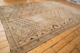 Distressed allover pattern of a vintage Shiraz carpet, revealing muted blush and sand tones.