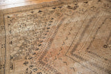 Distressed Shiraz rug, showcasing faded blush, sand, and charcoal geometric and curvilinear motifs.