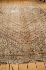 Distressed vintage Shiraz carpet with faded blush and sand tones, showing allover medallions.