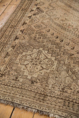 Distressed Shiraz carpet detail: sand, charcoal, blush geometric motifs, even pile, and fringe.
