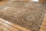 Vintage distressed Shiraz carpet with tribal geometric patterns in sand and charcoal tones.