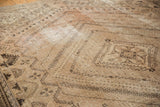 Angled close-up of distressed vintage Shiraz rug, showing faded geometric and floral motifs in sand, blush, and charcoal.