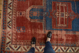 Antique Kazak carpet's upper prayer niche in sapphire blue, cherry red field, and aged texture.