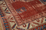 Antique Caucasian Kazak rug detail: cherry red field, blue geometric motif, serrated leaf border.