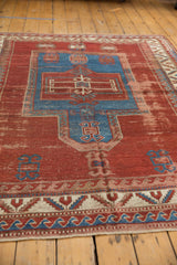 Sapphire blue wave and serrated leaf borders on antique Kazak rug with cherry red field wear.