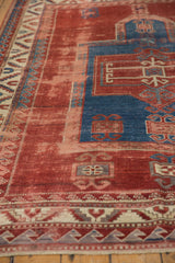 Antique Kazak rug's cherry red field, areas of foundation, and sapphire wave and serrated borders.