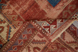 Folded antique Kazak carpet corner, showing worn cherry red pile and serrated leaf border.