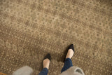 Distressed vintage Bokhara carpet displaying geometric borders and tone on tone medallions.