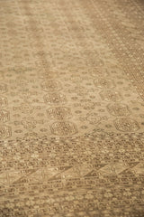 Distressed Bokhara carpet detail with tone-on-tone ivory and charcoal gul patterns and geometric borders.