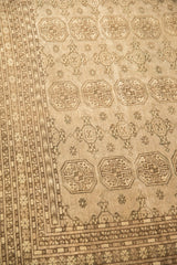 Distressed Bokhara carpet detail showing tonal grey elephant footprint guls and patterned border.