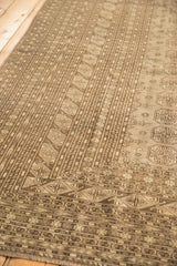 Vintage distressed Bokhara carpet close-up, highlighting even wear and tone-on-tone gul motifs.