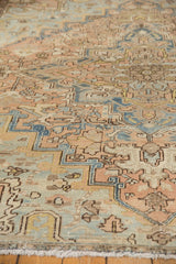 Distressed vintage Mehrivan carpet showing faded apricot, denim blue, and pale green stylized patterns.