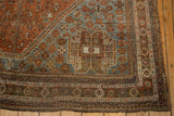 Distressed vintage Shiraz carpet corner with intricate borders, dusty slate blue spandrel, and aged floral patterns.