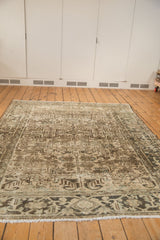 Faded geometric pattern and soft neutral tones of a distressed Mehrivan carpet.