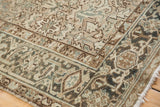 Corner detail of distressed Mehrivan carpet, showing geometric turtle border and muted ivory, teal tones.