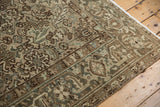 Distressed Mehrivan carpet corner, showing geometric turtle border in pale green, sand, and brown.