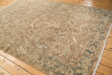 Distressed vintage Heriz carpet with even pile wear, sprawling floral motifs, and slate gray border.