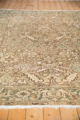 Distressed vintage Heriz rug's low pile, muted silver, blue, ivory patterns, and white fringe.