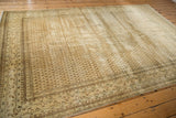 Corner detail of distressed Persian Mir Sarouk rug, intricate Mir Boteh pattern, muted tones.