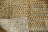 Vintage distressed Mir Sarouk carpet, corner folded to reveal hand-knotted foundation and worn pile.