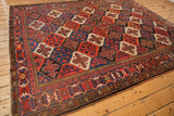 Vintage Baktiari carpet detail: repeating panel garden motif with lattice in madder red, indigo blue, black, ivory.