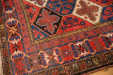 Vintage Baktiari carpet corner showing lattice outlines, panel garden motif in madder red, indigo, ivory.
