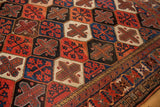 Baktiari rug lattice panels in madder red, cobalt blue, and ivory with patterned border.