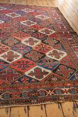 Detail of vintage Baktiari rug border and lattice panel garden motif in madder red, indigo blue, black, with secured end.