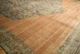 Antique Distressed Bibikabad rug's low pile, showing pale copper shadow gul and navy Herati designs.