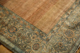 Distressed Persian Bibikabad carpet corner: worn Herati border with muted blues and coppers on low pile.