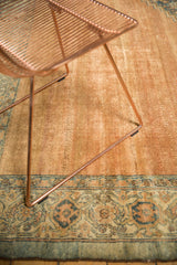 Distressed antique Bibikabad carpet showing faded copper field and intricate blue border motifs.