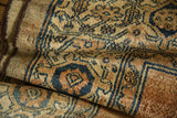 Herati pattern on distressed low pile of antique Bibikabad rug in muted blue and copper.