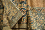 Close-up: antique Bibikabad rug's distressed low pile, intricate blue Herati pattern, secured edge.