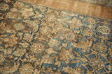 Textured distressed pile of an antique Bibikabad rug with blue and earthy Herati motif.