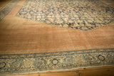 Antique Bibikabad carpet's distressed low pile, muted copper field, and intricate navy border.