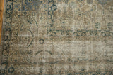 Distressed Sivas carpet close-up: aged texture, faded beige, silver, and charcoal blue vinery.